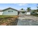 Charming single-story home with a well-maintained lawn, long driveway and decorative landscaping at 1004 Peninsula Ave, Tarpon Springs, FL 34689