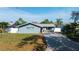 Charming single-story home with a well-manicured lawn, driveway, and inviting red front door at 1004 Peninsula Ave, Tarpon Springs, FL 34689