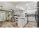 Open concept kitchen and dining area with modern white cabinets and stainless steel appliances at 1004 Peninsula Ave, Tarpon Springs, FL 34689
