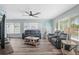 Inviting living room featuring a modern ceiling fan, wood flooring, and plenty of natural light at 1004 Peninsula Ave, Tarpon Springs, FL 34689