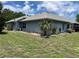 Home exterior showing blue siding, green grass, and a palm tree at 10054 Hernando Ridge Rd, Weeki Wachee, FL 34613