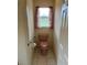 Small water closet bathroom with decorative floral curtains, pull bar and tile floor at 10054 Hernando Ridge Rd, Weeki Wachee, FL 34613