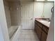 Tiled bathroom with a white tub, vanity, and tile flooring at 10054 Hernando Ridge Rd, Weeki Wachee, FL 34613