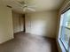 Bedroom with neutral carpet, white trim, fan, and bright window at 10054 Hernando Ridge Rd, Weeki Wachee, FL 34613
