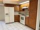 An eat-in kitchen featuring white appliances, light oak cabinetry and tile flooring at 10054 Hernando Ridge Rd, Weeki Wachee, FL 34613