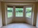 A cozy living area with a bay window overlooking the green lawn and landscape outside at 10054 Hernando Ridge Rd, Weeki Wachee, FL 34613