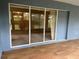 A covered patio with wood flooring and a sliding glass door that overlooks the backyard at 10054 Hernando Ridge Rd, Weeki Wachee, FL 34613