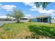 Spacious backyard featuring a white picket fence, lush grass, and a screened lanai on a sunny day at 1009 Summer Breeze Dr, Brandon, FL 33511