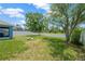 Lush backyard with green grass, white fencing, mature trees, and a cozy fire pit at 1009 Summer Breeze Dr, Brandon, FL 33511