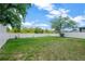 Expansive backyard with lush green grass, mature trees, and a pristine white fence at 1009 Summer Breeze Dr, Brandon, FL 33511