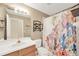 Bathroom with single sink vanity, tiled floor, and shower with playful curtain at 1009 Summer Breeze Dr, Brandon, FL 33511