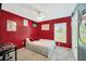 Cozy bedroom with vibrant red walls, plush carpet, and ample natural light from the window at 1009 Summer Breeze Dr, Brandon, FL 33511