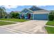 Inviting one-story home featuring a blue exterior, well-kept lawn, extended driveway, and attached two car garage at 1009 Summer Breeze Dr, Brandon, FL 33511