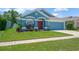 Attractive one-story home boasts a blue exterior, complemented by a vibrant green lawn and neat landscaping at 1009 Summer Breeze Dr, Brandon, FL 33511