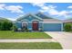 Charming one-story home with blue exterior, well-manicured lawn and landscaping, and a two car garage at 1009 Summer Breeze Dr, Brandon, FL 33511