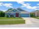 Beautiful one-story home showcases a blue exterior, lush green lawn, and attached two-car garage at 1009 Summer Breeze Dr, Brandon, FL 33511