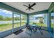 Cozy screened lanai with a ceiling fan and outdoor dining set, offering a pleasant view of the backyard at 1009 Summer Breeze Dr, Brandon, FL 33511