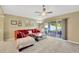 Cozy living room with a red sofa, ceiling fan, and sliding doors to the outdoor patio area at 1009 Summer Breeze Dr, Brandon, FL 33511
