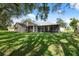 A wide green lawn connects the main home to an additional screened patio area, perfect for relaxing at 10296 Palmgren, Spring Hill, FL 34608