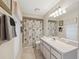 Bright bathroom with a white vanity, patterned shower curtain, and natural light at 10296 Palmgren, Spring Hill, FL 34608