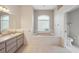 Bathroom featuring double sinks, a large soaking tub, and a window at 10296 Palmgren, Spring Hill, FL 34608