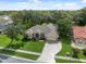 Aerial view of a home with lush landscaping, mature trees, and a well-maintained lawn at 10296 Palmgren, Spring Hill, FL 34608