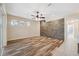 Spacious living room features wood floors, stone accent wall, and ceiling fan at 10296 Palmgren, Spring Hill, FL 34608