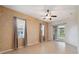 Bright living room with a ceiling fan, sliding glass door to screened porch, and neutral tile flooring at 10296 Palmgren, Spring Hill, FL 34608