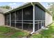 The screened in lanai features a dark screen and white frame attached to the house's exterior at 10296 Palmgren, Spring Hill, FL 34608