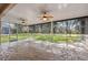 This screened patio features a unique stone floor, multiple ceiling fans, and an excellent view of the backyard at 10296 Palmgren, Spring Hill, FL 34608