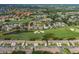 Aerial view of a residential community with lush green golf courses, serene lakes, and well-maintained homes at 1105 Flora Vista St, New Port Richey, FL 34655