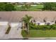 Aerial view of a one-story home featuring landscaping, a double-car garage, and golf course in the background at 1105 Flora Vista St, New Port Richey, FL 34655