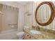 Bathroom featuring a granite countertop, golden framed mirror, and shower-tub combination at 1105 Flora Vista St, New Port Richey, FL 34655