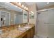 Well-lit bathroom featuring granite counters, a large mirror, and a glass-enclosed shower at 1105 Flora Vista St, New Port Richey, FL 34655