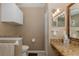 Neat bathroom with granite counters, wall-mounted storage, and a toilet at 1105 Flora Vista St, New Port Richey, FL 34655
