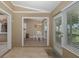 Open dining area with white table and chairs, tile floors, and view to the kitchen and screened lanai at 1105 Flora Vista St, New Port Richey, FL 34655
