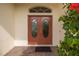 A close up of a double door entrance with a brick paver walkway and tropical landscaping at 1105 Flora Vista St, New Port Richey, FL 34655