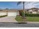 Charming one story home featuring a double door entrance, a double-car garage, and a well-manicured lawn at 1105 Flora Vista St, New Port Richey, FL 34655