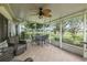 Relax on this screened lanai featuring a ceiling fan, brick floor, and a beautiful lawn view at 1105 Flora Vista St, New Port Richey, FL 34655
