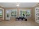 Spacious sunroom featuring tile floors, ceiling fan, a cozy fireplace and an outdoor view at 1105 Flora Vista St, New Port Richey, FL 34655