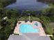 Aerial view of a community pool, lounge chairs, and a clear lake at 11055 Belle Haven Dr, New Port Richey, FL 34654