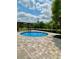 Inviting backyard pool with a paved deck, metal fence, and relaxing outdoor space at 11055 Belle Haven Dr, New Port Richey, FL 34654