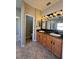 Dual sink bathroom with granite countertops, wood cabinets, large vanity mirror and views of the shower at 11055 Belle Haven Dr, New Port Richey, FL 34654