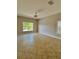 Neutral bedroom featuring tile flooring, bright lighting, and a large window for natural sunlight at 11055 Belle Haven Dr, New Port Richey, FL 34654