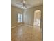 This bedroom features tiled floors, a ceiling fan, and a window with plantation shutters at 11055 Belle Haven Dr, New Port Richey, FL 34654