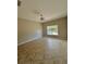 This spacious bedroom features tile flooring, bright lighting, and a large window with backyard views at 11055 Belle Haven Dr, New Port Richey, FL 34654