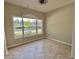 Bright bedroom featuring tile flooring, neutral walls, and a large window with a street view at 11055 Belle Haven Dr, New Port Richey, FL 34654