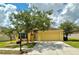 Single-story home with tan exterior, well-maintained lawn, and two-car garage at 11055 Belle Haven Dr, New Port Richey, FL 34654
