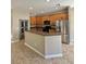 Modern kitchen featuring wood cabinets, granite countertops, and stainless steel appliances at 11055 Belle Haven Dr, New Port Richey, FL 34654
