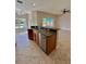 Open kitchen features a granite countertop island with a stainless steel dishwasher and views of the living area at 11055 Belle Haven Dr, New Port Richey, FL 34654